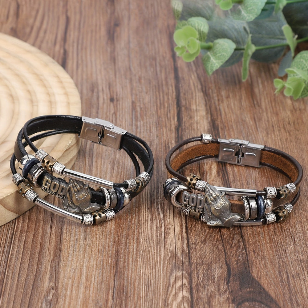 Christianartworkshop Pulsera de cuero con manos en oración y detalles metálicos que dice "Dios me bendiga". - image 1