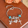 Christianartworkshop Pulsera con dije de ángel y cruz para la Primera Comunión Infantil: un símbolo de fe y bendición divina. - Primera Comunión - image 0