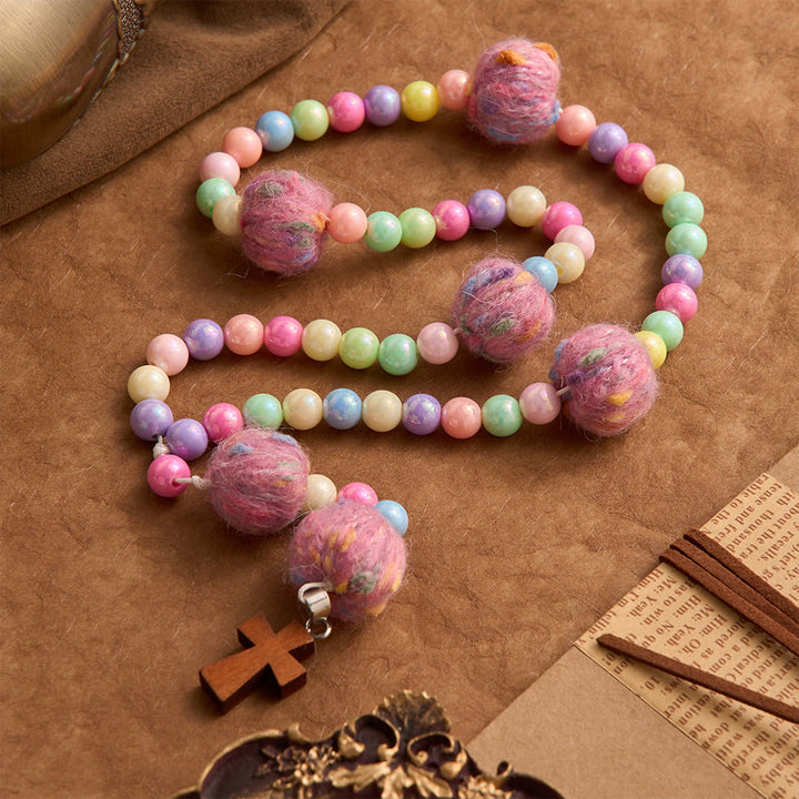 Christianartworkshop Rosario infantil de cuentas de macaron con pompones esponjosos y cruz de madera: emblema de la bondad celestial inocente. - image 2